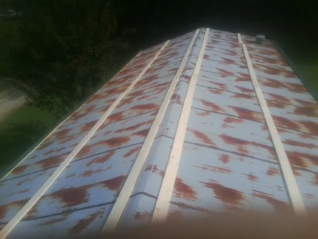 Rusted metal roof panels with new wood purlins before replacement — Storm Damage Roof Repair in Hillside by Roofing Brothers