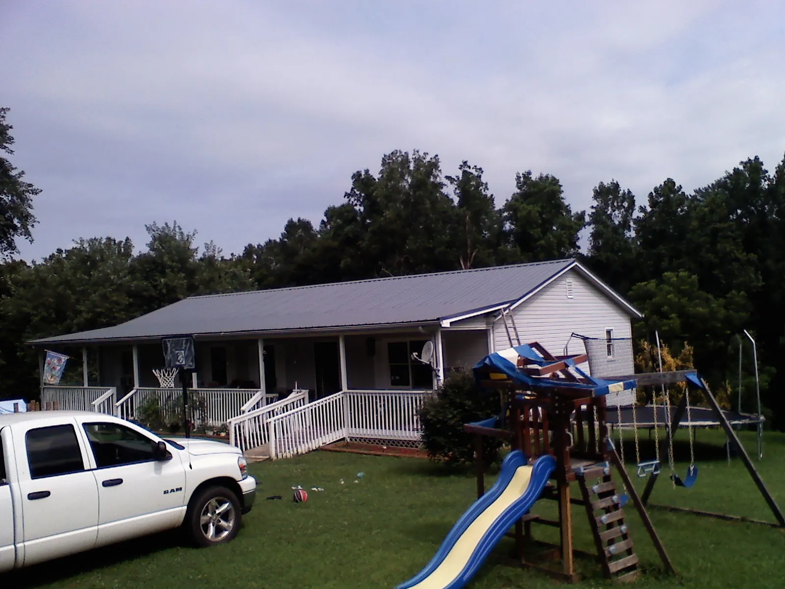 Dark metal roof on a country home with a full length front porch in Hillside